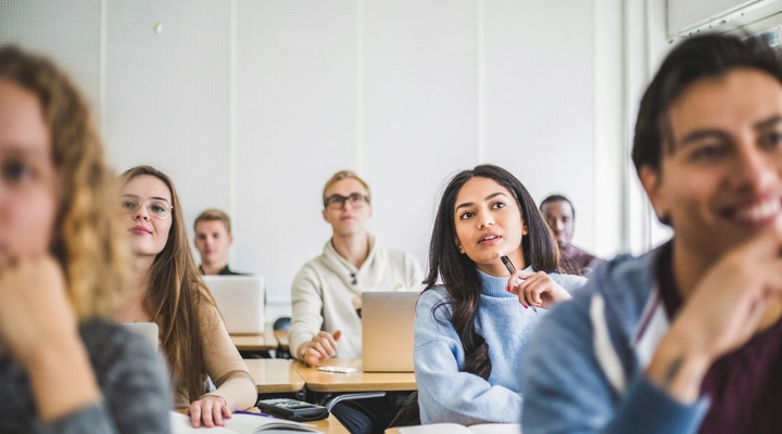 Klassenzimmer voller junger Studendierender mit Laptops