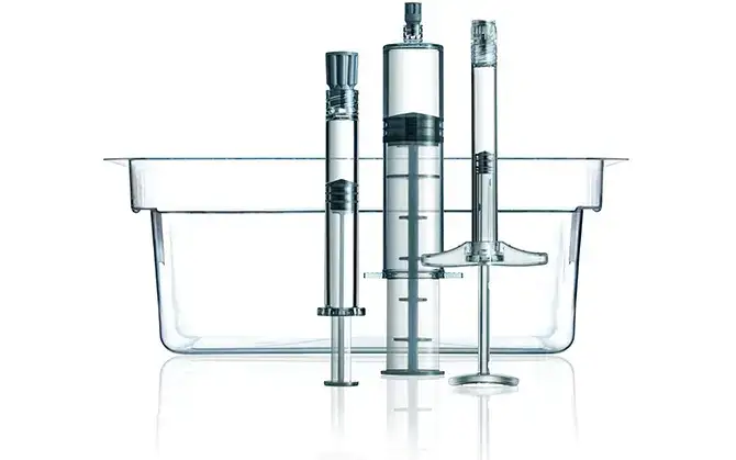 Reihe von drei transparenten SCHOTT TOPPAC® cosmetic Spritzen in verschiedenen Größen vor einer Tub-Verpackung