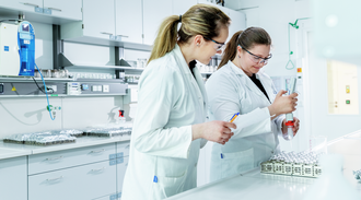 Two female technicians examine sample in a laboratory
