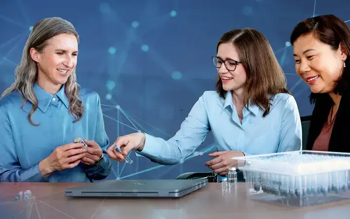 Women smiling over a laptop while working