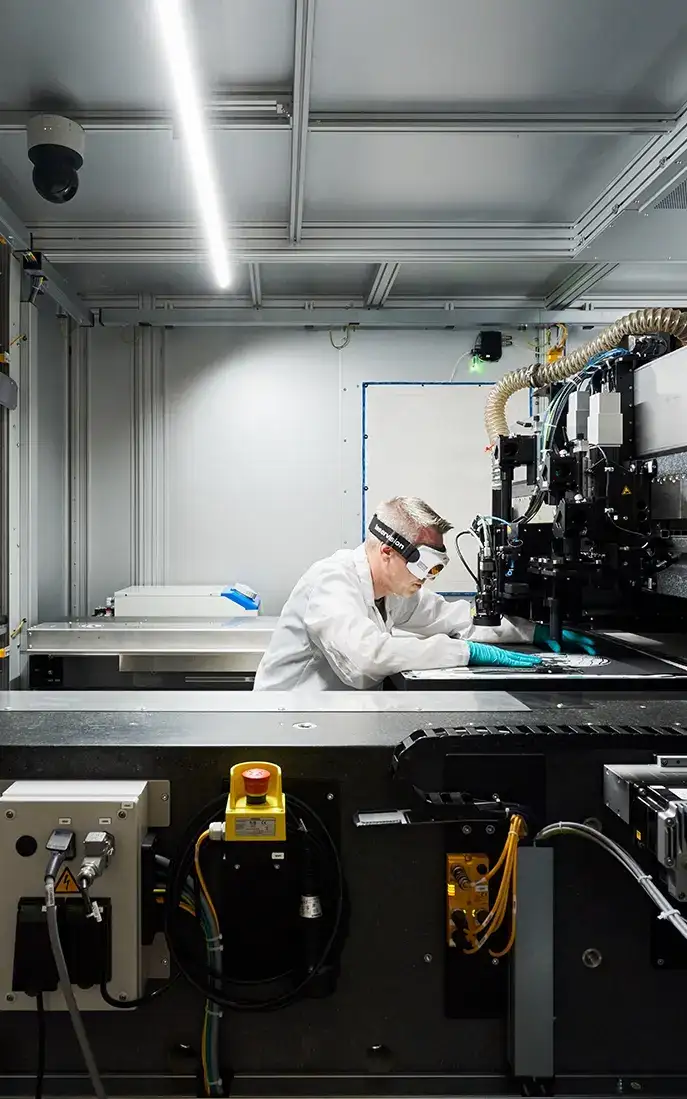 Homem usando óculos de segurança trabalhando em uma máquina em uma área de produção