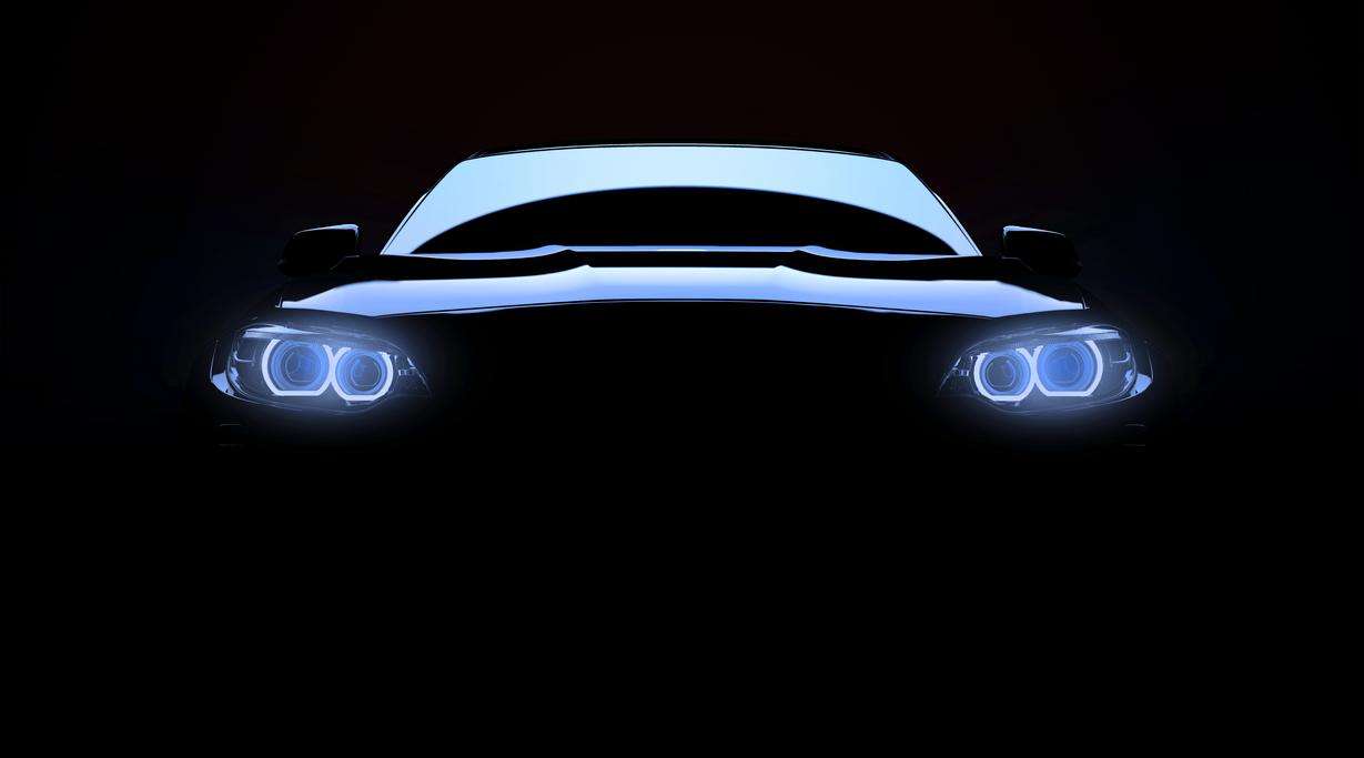 Front view of a car in darkness with headlights on