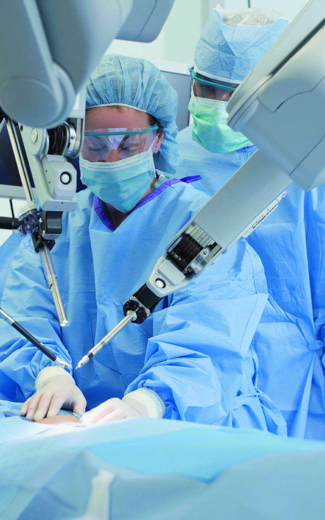 Two surgeons in an operating room doing a minimally invasive surgery with endoscopes in which SCHOTT's light guides are used