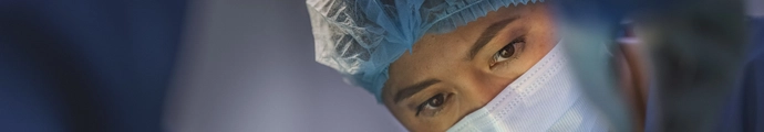 Female surgeon looking at a patient in a hospital operating theatre