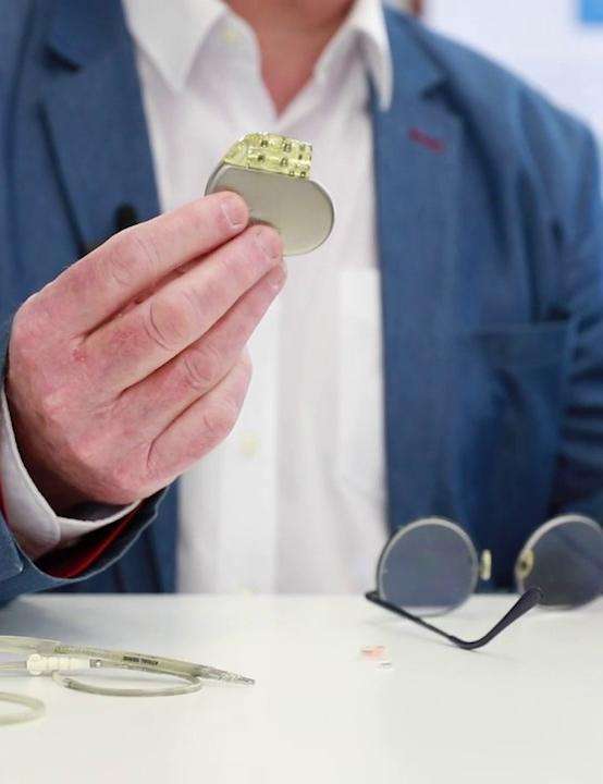 Photo showing a person holding a pacemaker in his hand.