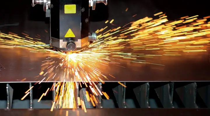 Orange sparks flying off a laser cutting machine 