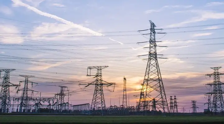 Rows of electrical pylons with sunset background