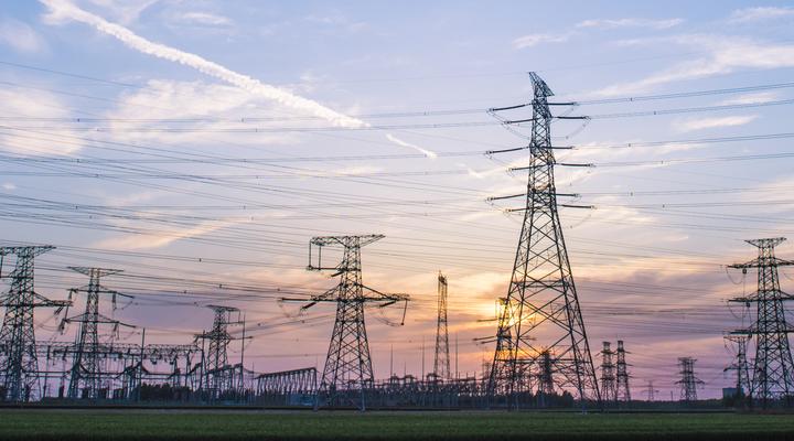 Rows of electrical pylons with sunset background