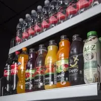 Two retail shelves full of soft drink bottles