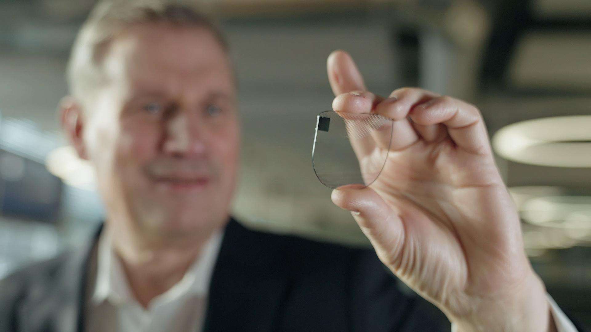 CEO Dr. Heinricht holding a waveguide for Augmented Reality
