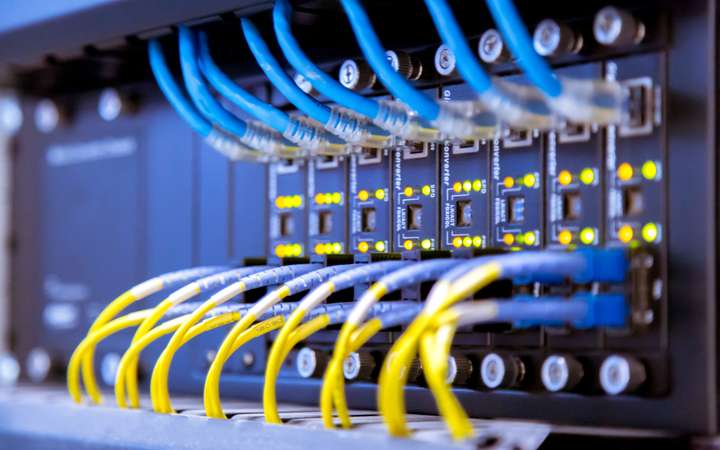 Series of blue and yellow wires going into a network device