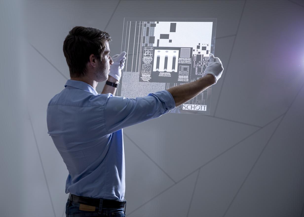 Man in gloves examining a panel of structured glass  