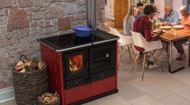 Family eating around table in kitchen with wood cook stove