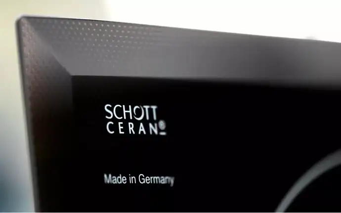 Close up of the SCHOTT CERAN® logo on a black glass-ceramic cooktop panel