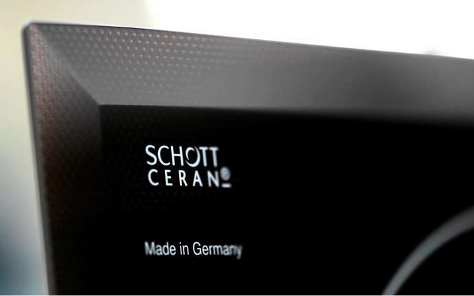 Close up of the SCHOTT CERAN® logo on a black glass-ceramic cooktop panel