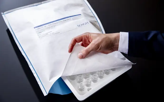 Hand opening a SCHOTT iQ® Integribag for ready-to-use pharma containers