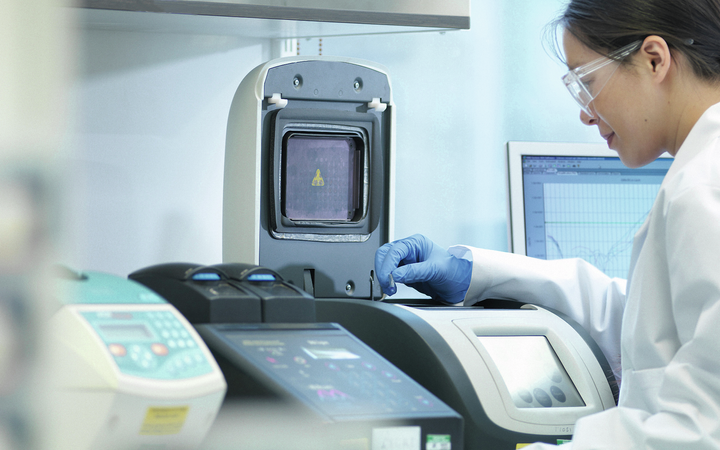 Female scientist surrounded by equipment in a laboratory