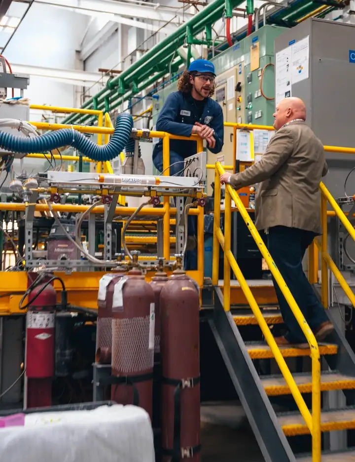 Two scientists discussing next to a melting tank