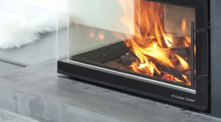 Indoor fireplace with SCHOTT ROBAX® angular bent fire-viewing panel