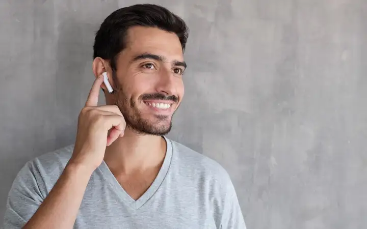 Bearded man wearing bluetooth earbud