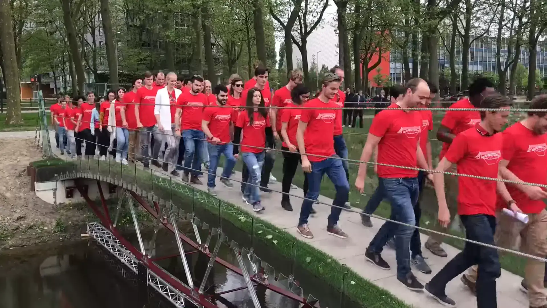 네덜란드 델프트 공과대학에서 유리 교량을 건너는 빨간 티셔츠를 입은 학생들
