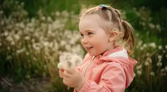 A child holding a dandelion