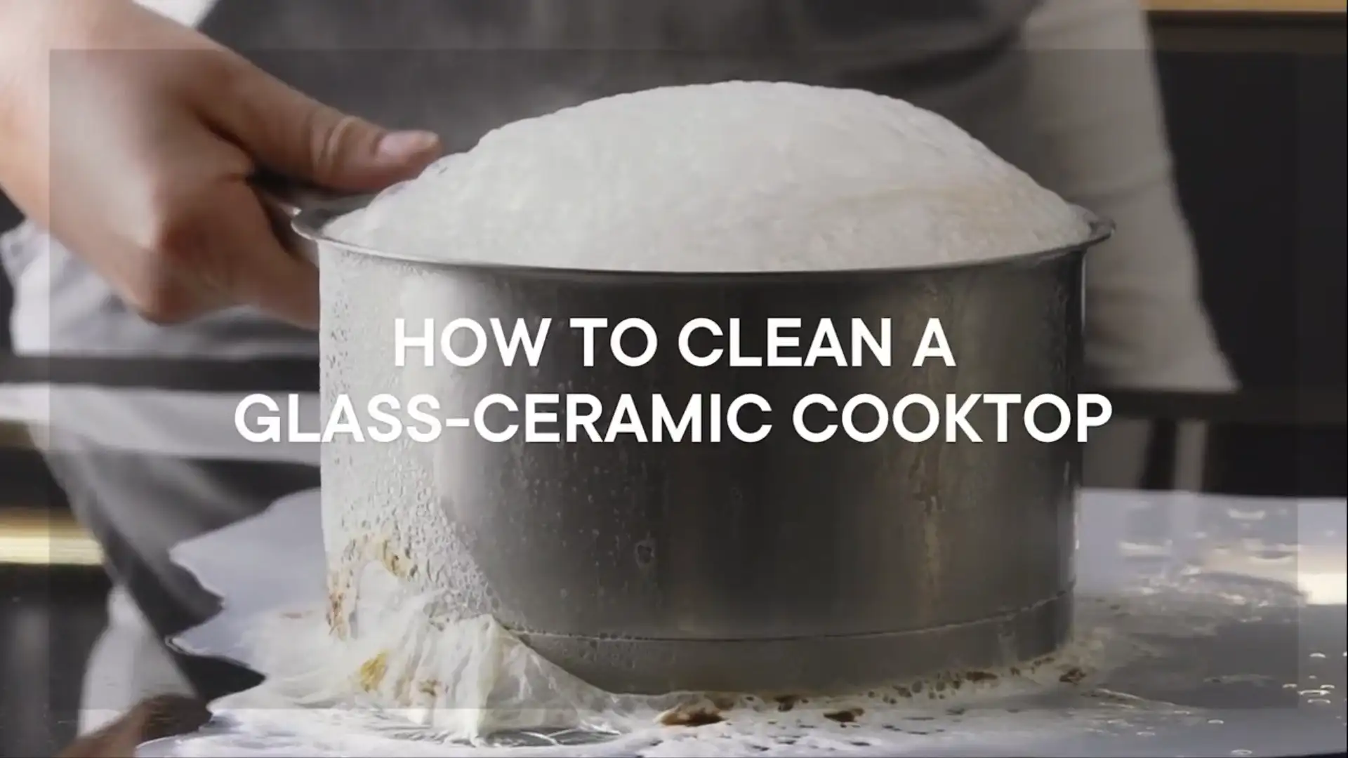 Milk boiling over in a pot that sits on a vitroceramic cooktop