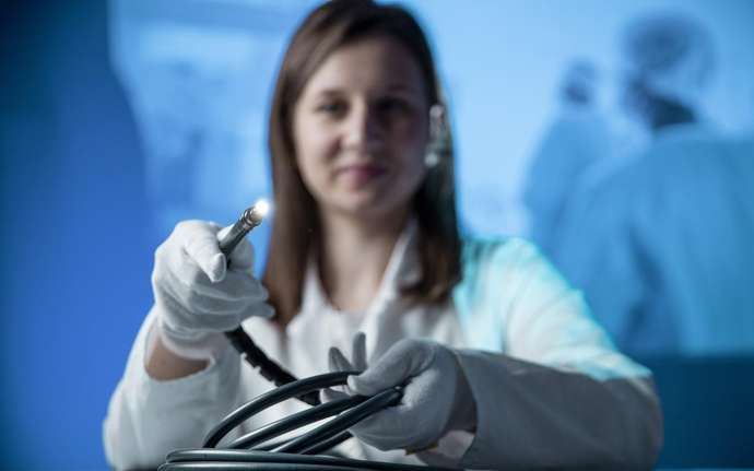 Chirurgin präsentiert leuchtenden Lichtleiter aus Glasfasern von SCHOTT.