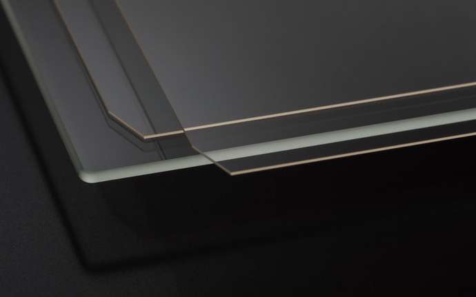 Stack of thin glass panels on a dark background