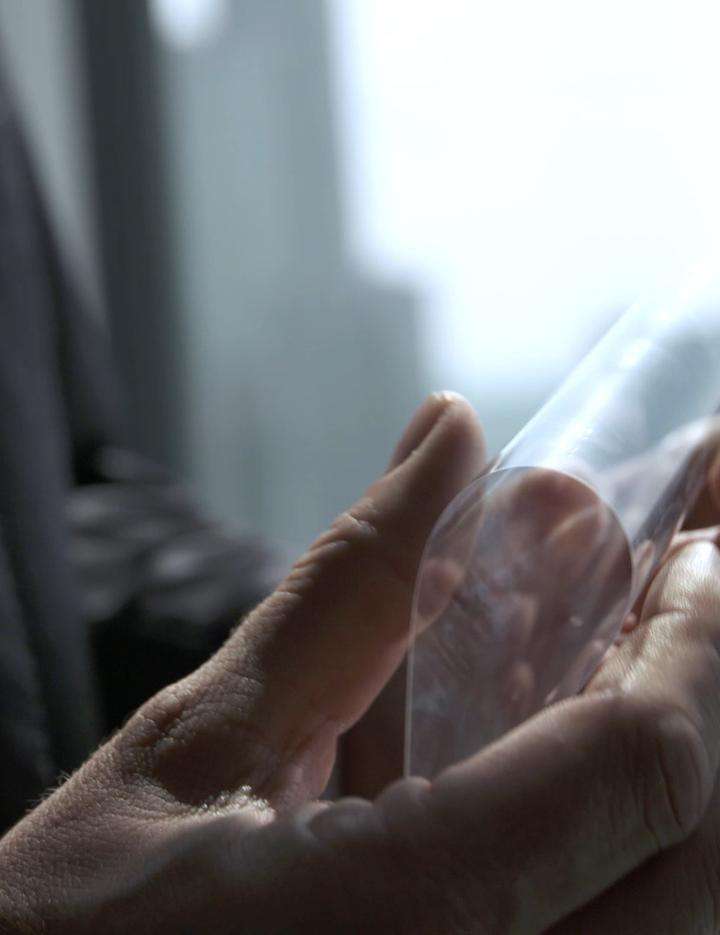 Businessman holding a sample of SCHOTT Xensation® Flex cover glass