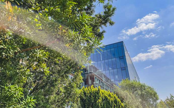SCHOTT glass building in sunlight surrounded bytrees