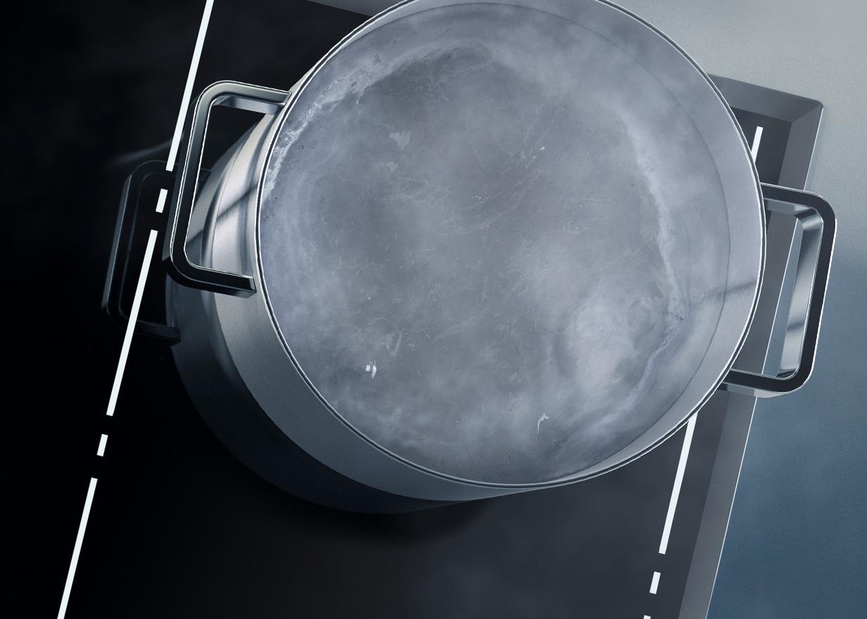 Pfanne mit kochender Flüssigkeit auf einem schwarzen Kochfeld mit beleuchteten Linien	