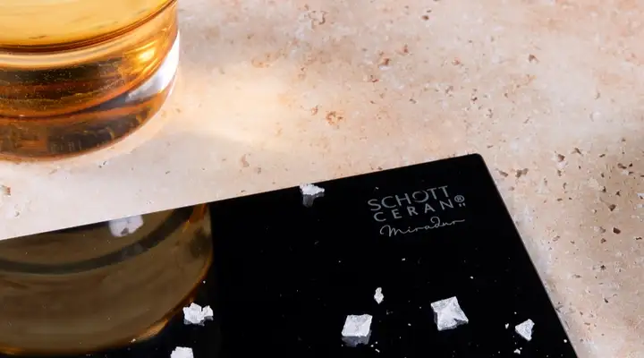 SCHOTT CERAN® Miradur glass-ceramic cooktop with salt crystals and popcorn residue on the surface, illustrating resistance to everyday kitchen challenges. 