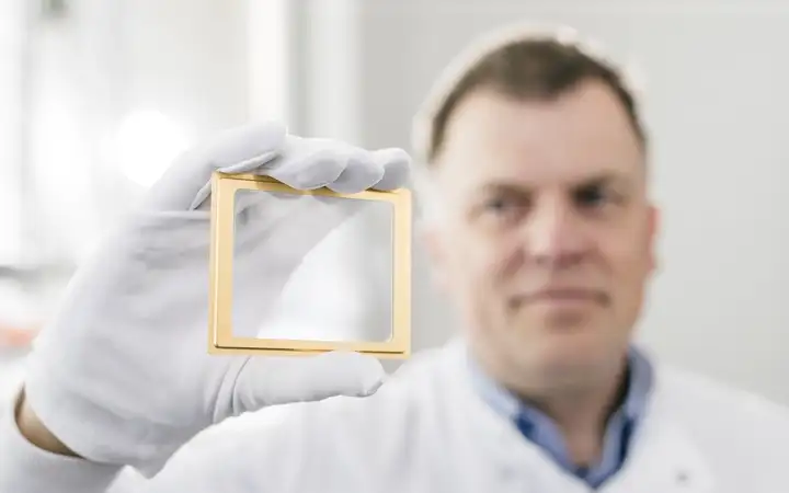 Man holding a small window with golden frame