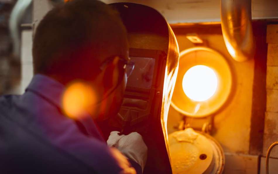 	SCHOTT engineer inspects a glass melting tank behind protective equipment