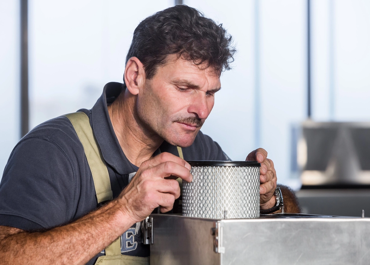 Ingénieur Triplan Umwelttechnik travaillant sur un système de ventilation photocatalytique