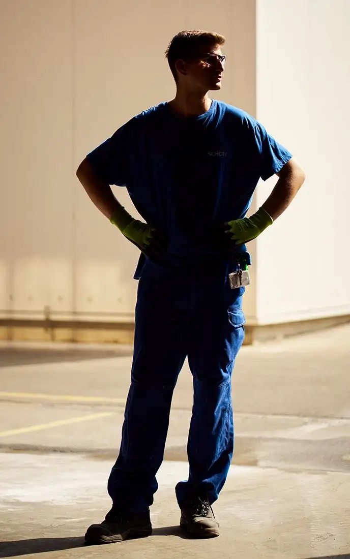 Worker in blue uniform standing with hands on hips