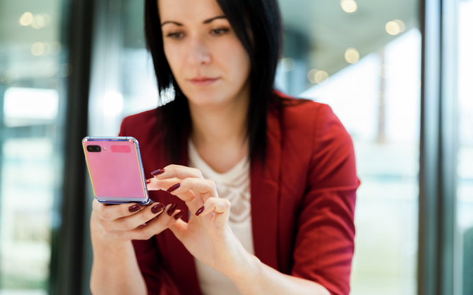 Frau die ein faltbares Smartphone nutzt