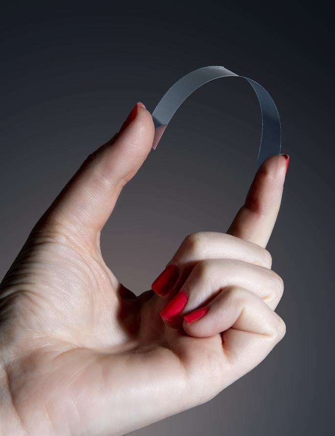 Damenhand biegt ultradünnes Glas von SCHOTT