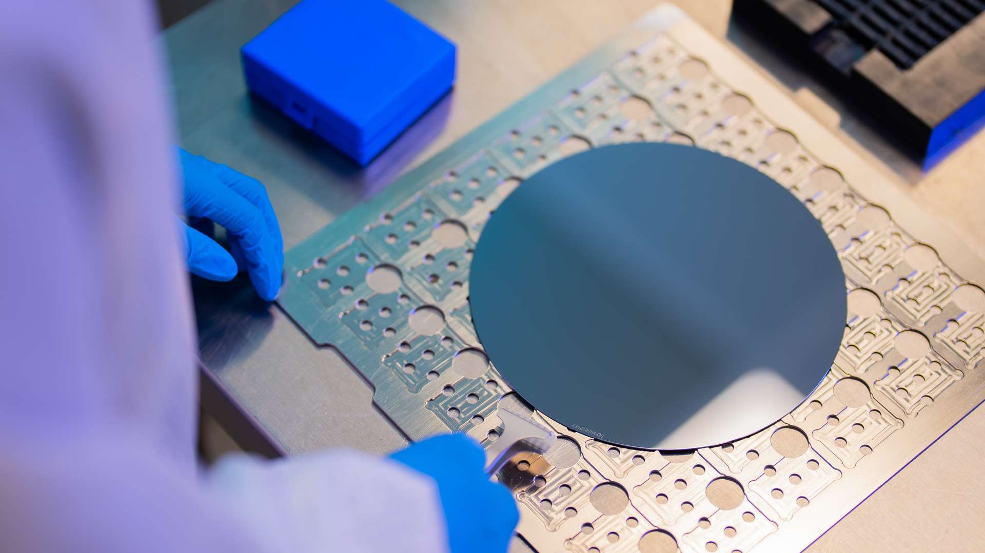 Gloved hands handling a wafer