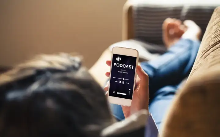 Woman looking at smartphone with podcast on the display