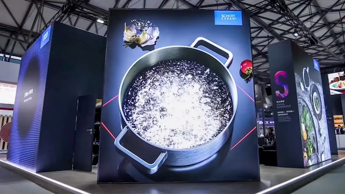 Boiling water in a pot with red illuminated cooking zone on the exhibition booth wall at AWE in Shanghai 