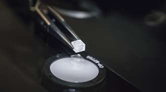 Tweezers holding a small glass component