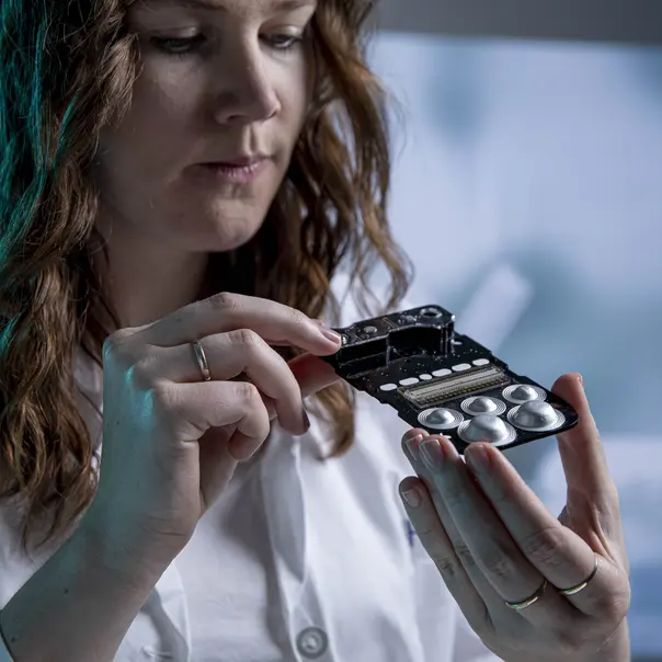 A scientist checks the diagnostics test on a microfluidic chip