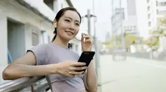 A person holding a phone and wearing ear pods.