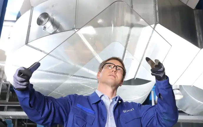 Ingenieur von SCHOTT inspiziert eine ROBAX® Feuersichtscheibe  