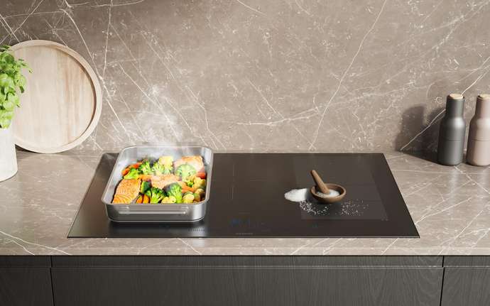 Kitchen worktop with black cooktop and decorative items