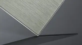 Close-up of a brushed textured glass panel with a metallic finish on a dark background.