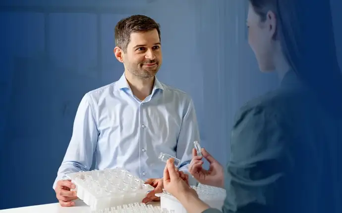 Men and women standing at a table with vials