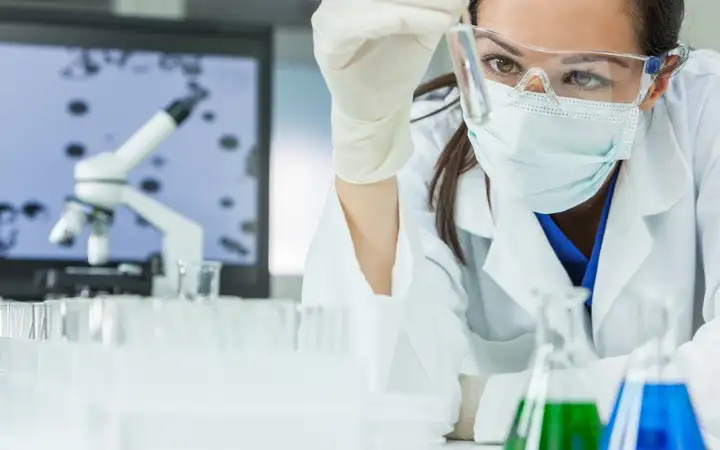 Scientist placing a series of glass tubes into a diagnostics device